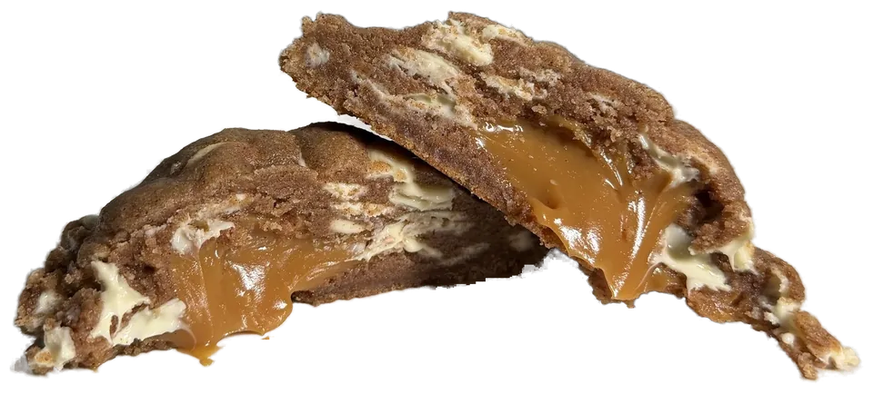 Cookie Ambar partido ao meio, com o recheio de doce de leite escorrendo