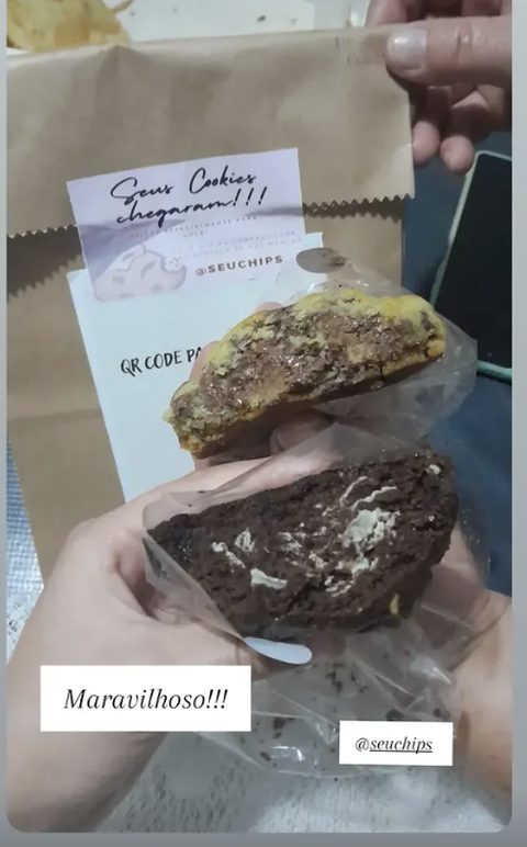 Story de cliente: saco kraft da entrega e a mão segurando um cookie Classic e um Onyx embalados